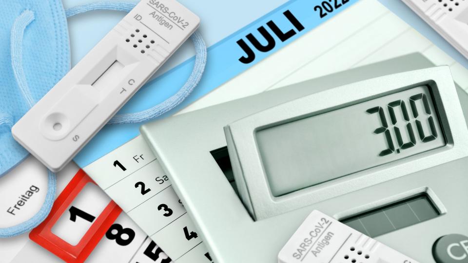 Kalenderblatt von Juli 2022, darauf liegen Coronatests und ein Taschenrechner der eine drei anzeigt, für die 3 Euro, die ein Test u. U. kostet.