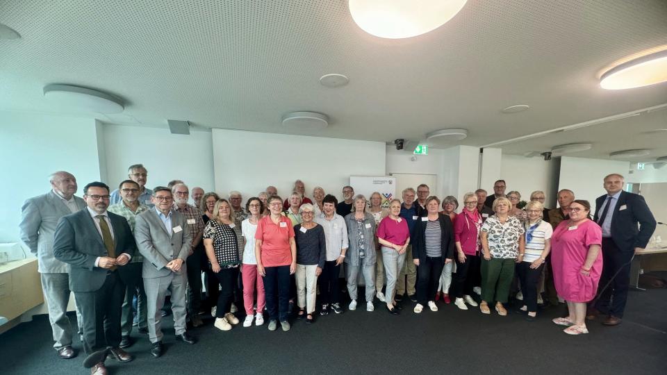 Gruppenbild der Teilnehmerinnen und Teilnehmer in dem Veranstaltungsraum